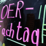 Auf einem schwarzen Hintergrund ist in neonpink "OER-Fachtag" zu lesen. Drumherum befinden sich neongrüne Linien zur Verzierung.
