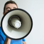 Man holding megaphone in front of his face