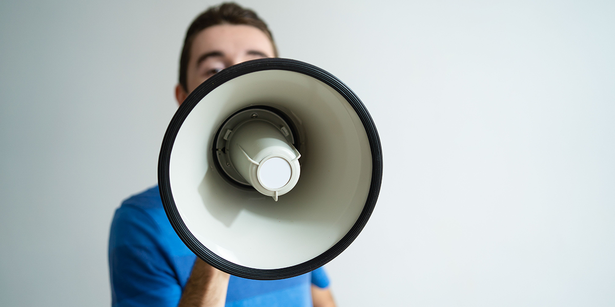 Man holding megaphone in front of his face